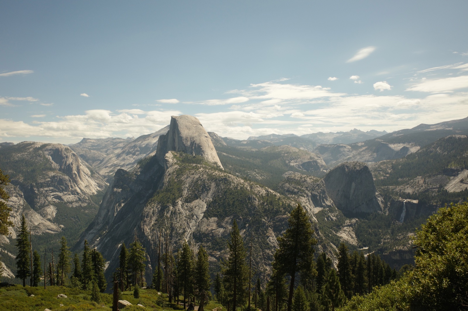Half Dome and the surrounding Yosemite landscape beneath a cloud-filled sky
